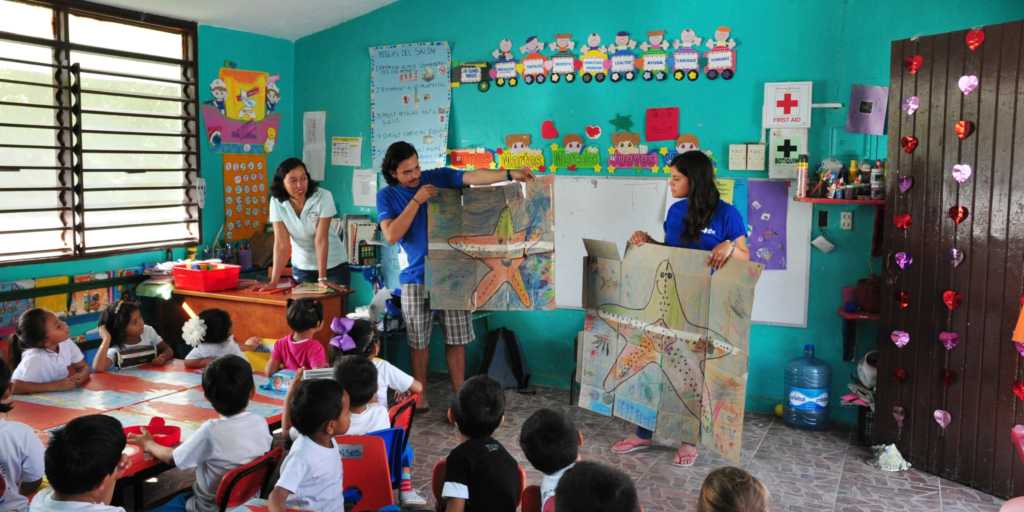 The picture depicts a group of enthusiastic children, engaged in a lively discussion about climate change and its consequences, highlighting the importance of education in creating a sustainable future. Picture Courtesy:gvi.co.uk